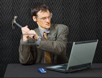 Comical person intends to break computer with hammer