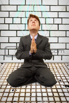 Comic businessman on knees praying