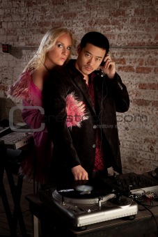 Asian DJ with blond woman at 1970s Disco Music Party