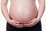 closeup of a pregnant woman touching her belly - isolated on white