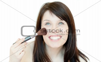 Radiant woman using a powder brush 