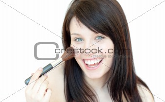 Happy woman using a powder brush 