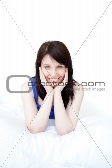Portrait of a smiling woman sitting on her bed 