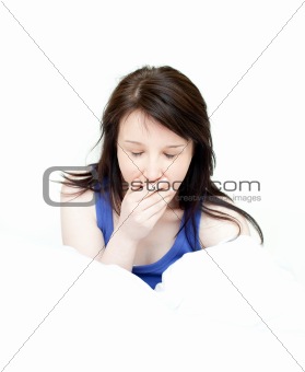 Charming woman yawning sitting on her bed 