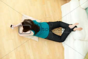 Young woman listening music lying down on the floor