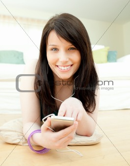 Delighted woman listening music lying on the floor