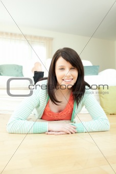 Attractive woman lying down on the floor in the living room
