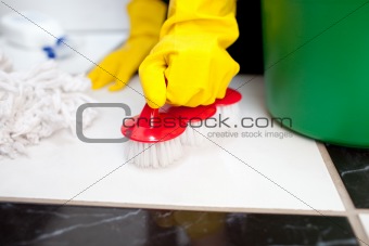 Woman cleaning a bathroom's floor 