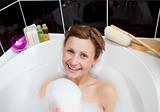 Smiling woman playing in a bubble bath 