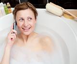 Radiant woman talking on phone in a bubble bath 