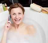 Bright woman talking on phone in a bubble bath
