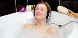 Relaxed woman listening music in a bubble bath 