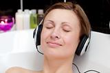 Close-up of a relaxed young woman listening music in a bubble ba