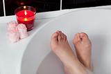 Bathtime. Girl's feet standing in bath tub.