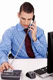 young business man sitting at his desk talking over phone