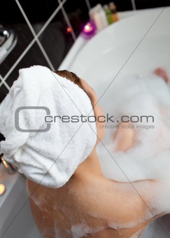 Young woman taking in a bubble bath 