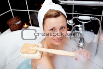 Smiling caucasian woman taking in a bubble bath 
