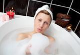 Delighted woman having fun in a bubble bath 