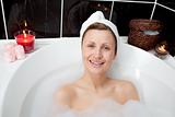 Positive woman relaxing in a bubble bath