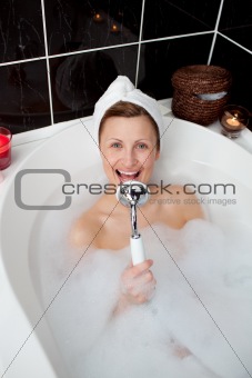 Happy woman singing in a bubble bath 