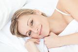 Delighted relaxed woman lying on her bed 