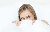 Close-up of a woman hiding in her bed 