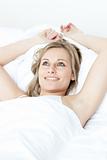Radiant woman relaxing  lying on a bed 
