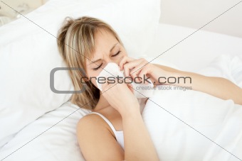 Sick woman blowing lying on her bed