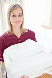 Positive cleaning lady holding towels