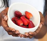 Close-up of a woman holding a bowl of strawberries 