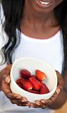 Afro-american a woman holding a bowl of strawberries 