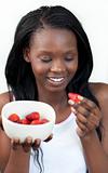 Cheerful Afro-american a woman eating strawberries