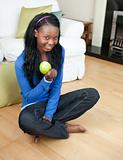 Happy woman eating an apple sitting on the floor