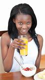 Smiling Afro-American drinking an orange juice