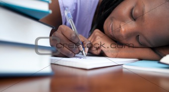 Close-up of a tired afro-american teen girl studying