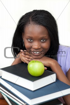 Young student holding books smiling at the camera 