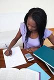 Concentrated Afro-American teen girl doing her homework 
