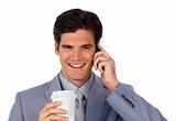 Positive businessman on phone and drinking a coffee