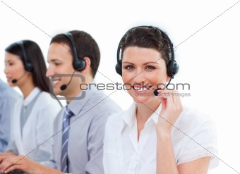 Attractive young woman working in a call center with her colleagues