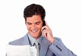 Happy businessman on phone holding a newspaper 