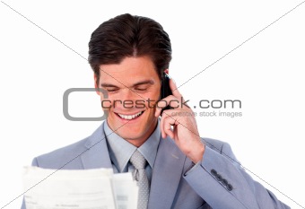 Happy businessman on phone holding a newspaper 
