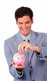 Smiling businessman saving money in a piggy-bank 