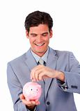 Assertive businessman saving money in a piggy-bank 