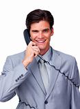 Smiling male executive tangle up in phone wires 