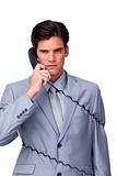 Annoyed businessman tangle up in phone wires 
