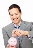 Attractive businessman saving money in a piggy-bank 