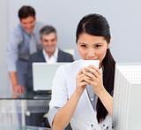 Brunette woman drinking coffee in the office