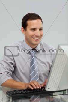 Charming young businessman working at a computer 