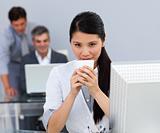 Assertive Businesswoman drinking a coffee at her desk 