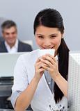 Smiling confident Businesswoman drinking a coffee at her desk 